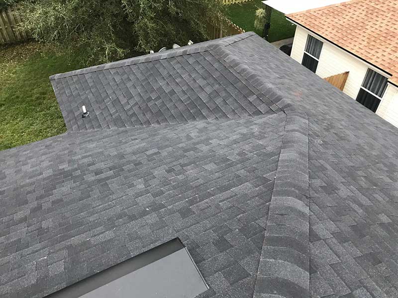 Close up top view of a residential roof with brand new dark gray shingles installed by Arica Roofing & Construction LLC